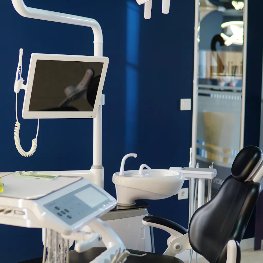 Lacivert klinik odasında ekranlı diş üniti ve hasta koltuğu