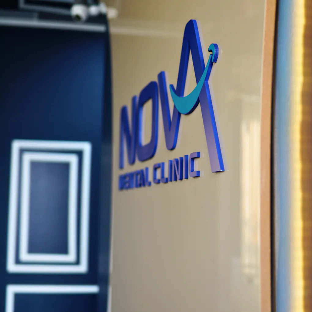 Klinik duvarında lacivert ve turkuaz NOVA DENT logosu