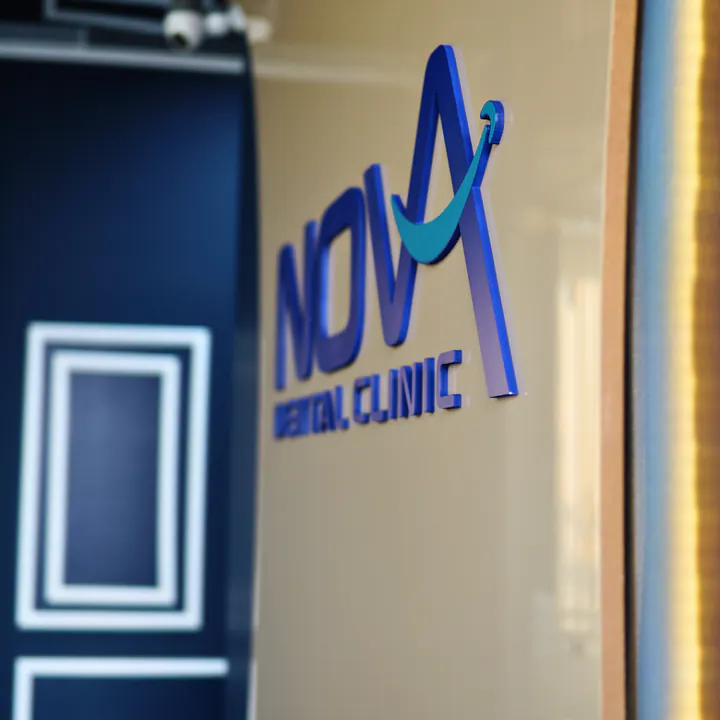 Klinik duvarında lacivert ve turkuaz NOVA DENT logosu